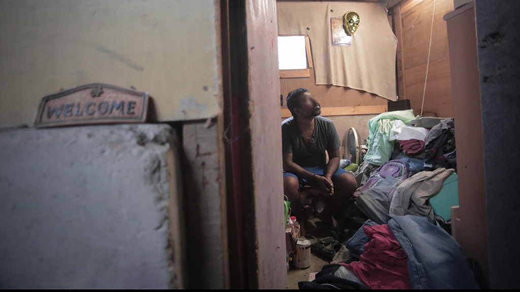 Refugee sits in a cubicle paid by ISS-HK in an abandoned chicken farm in Lam Tei.
